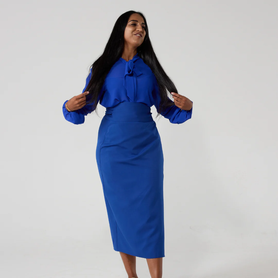 Electric blue pussy bow shirt worn by a woman in matching wrap skirt